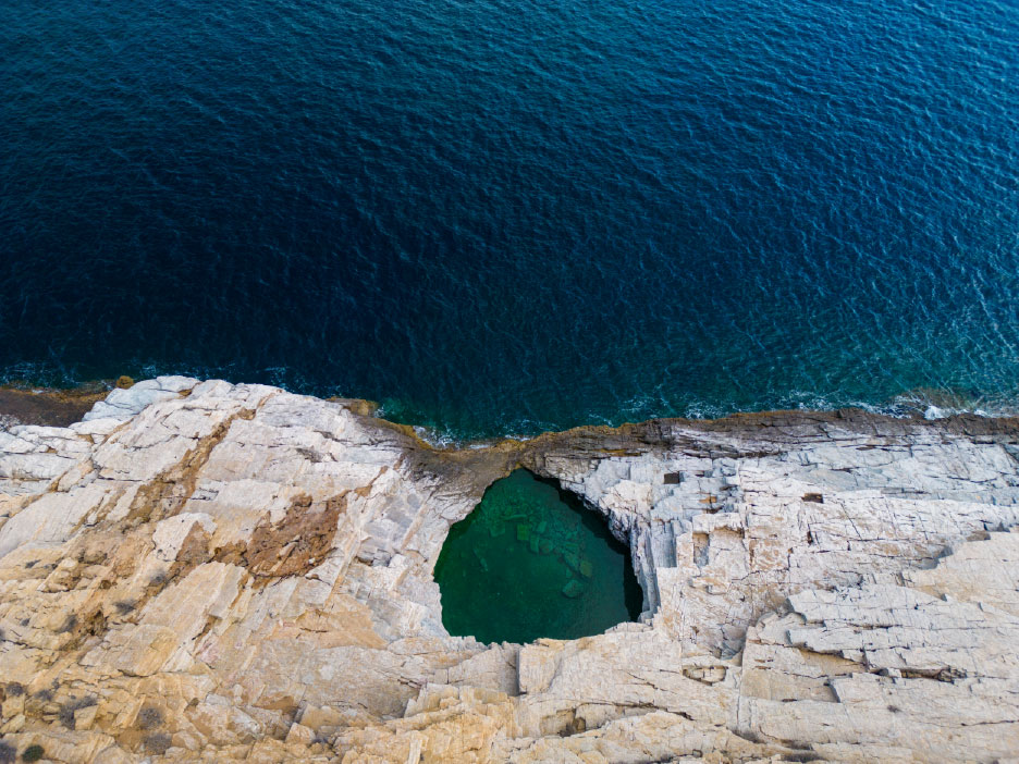 Aerial drone shot of Giola natural rock pool on the Thassos cliff edge
