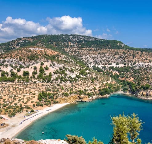 Aerial view of a Thassos coastal village with sandy beach and turquoise bay